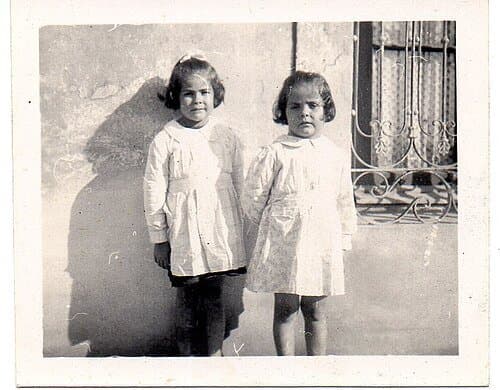 Fotografía de referencia de dos niñas con guardapolvo blanco